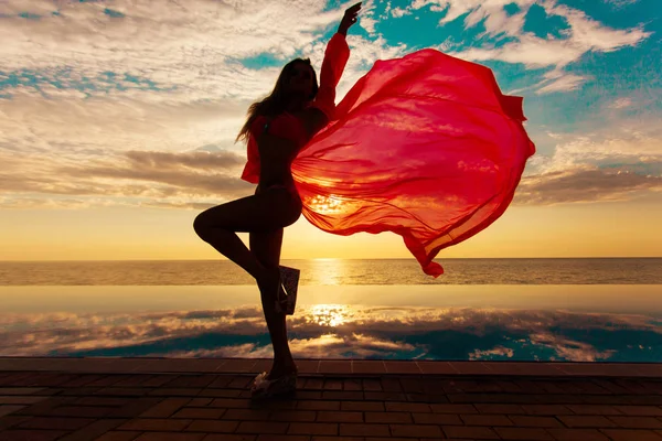 Letní dovolená. Silueta krása tančící ženy na sunset u bazénu s výhledem na oceán. — Stock fotografie