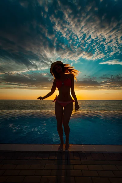 Sommerferien. Silhouette der Schönheit tanzende Frau bei Sonnenuntergang am Pool mit Meerblick. — Stockfoto