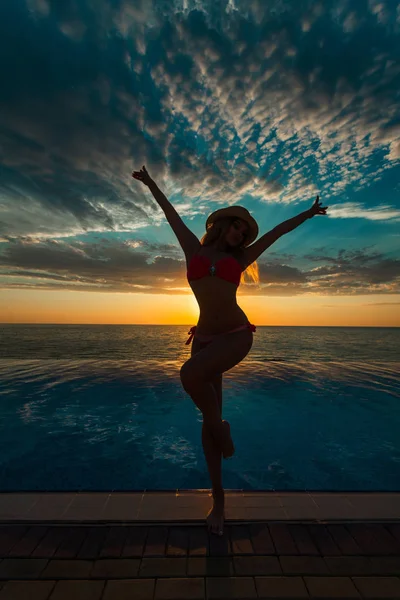 Sommerferien. Silhouette der Schönheit tanzende Frau bei Sonnenuntergang am Pool mit Meerblick. — Stockfoto