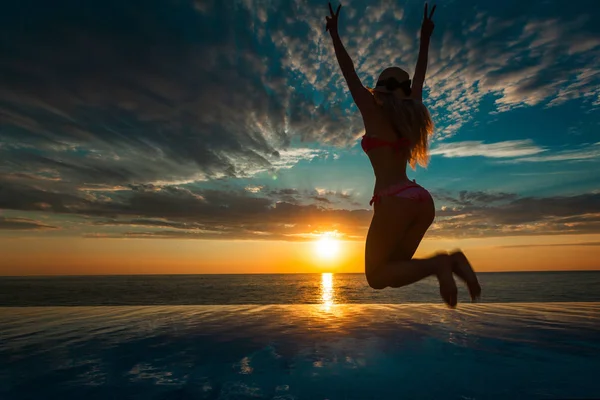Sommerferien. Silhouette der Schönheit tanzende Frau bei Sonnenuntergang am Pool mit Meerblick. — Stockfoto