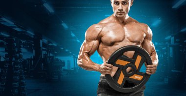 Acımasız güçlü kas vücut geliştirmeci atletik erkek yakışıklı erkekler spor salonu çıplak gövde egzersizleri yapıyor kaslar egzersiz vücut geliştirme kavramı arka plan - pompa. Spor beslenme reklamlar için kopya alanı.