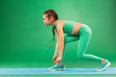 Yeşil arka plan üzerinde Fitness egzersizleri yapıyor çocuk kız