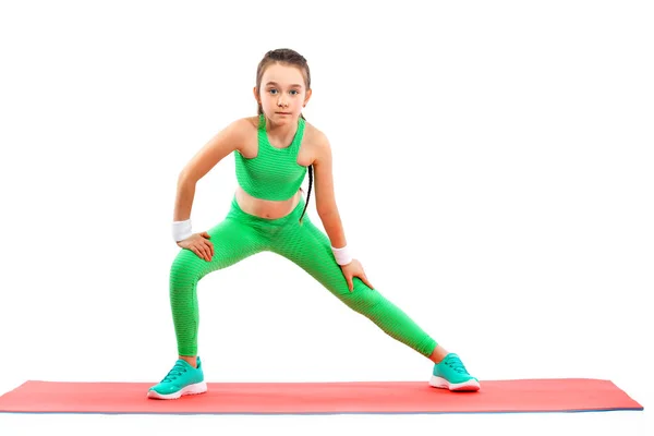 Kid girl doing fitness or yoga exercises isolated on white background. Sport concept. — Stock Photo, Image