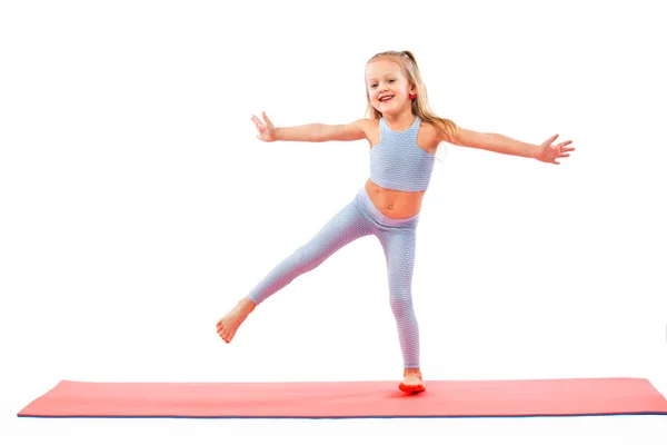 Kid girl doing fitness or yoga exercises isolated on white background. Sport concept. — Stock Photo, Image