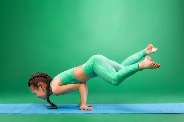 Kluk holka dělá fitness cvičení na zeleném pozadí — Stock fotografie
