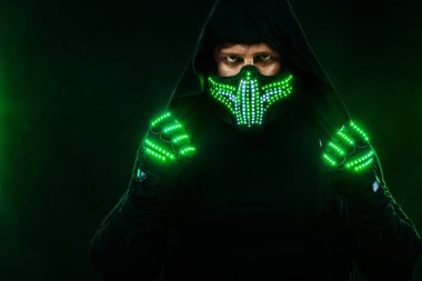 Siyah giymek, neon maske ve eldiven gizemli adam. Karakter papaz veya Sihirbazı gelecekten gelen elbise içinde. Suikastçi ile güçlü yüz ifadesi. Fantasy kitap ya da bilgisayar oyunu kapak konsepti.
