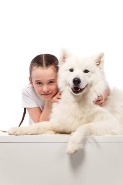 Beyaz köpek ile mutlu bir çocuk. Portre kız ile evde beslenen hayvan. Smilyng Samoyed Laika köpek.