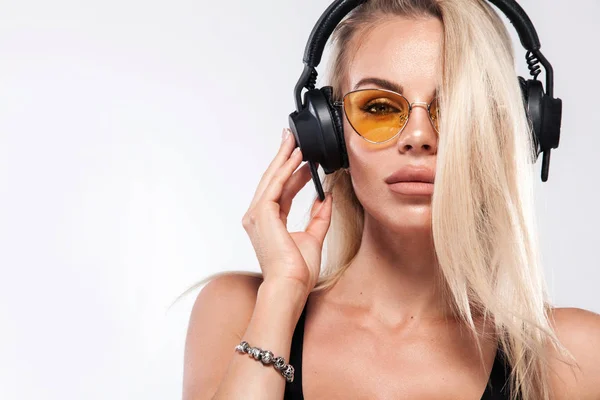 Primer plano retrato de hermosa sexy rubia DJ mujer en fondo blanco en el estudio con auriculares . — Foto de Stock