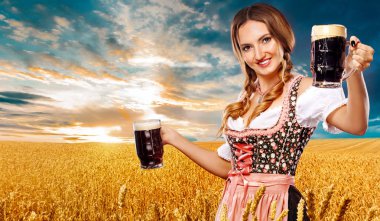 Bira partisi. Seksi Oktoberfest kadın - garson, bir geleneksel Alman Bavyera elbise giyen Münih'te büyük bira bardağı altın buğday alan arka plan üzerinde hizmet veren.