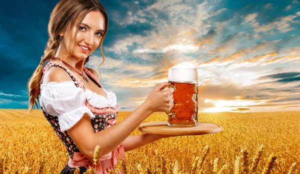 Bier partij. Sexy vrouw bij de Oktoberfest - serveerster, in München het dragen van een traditionele Duitse Beierse kleding, serveren grote bierpullen op gouden tarwe veld achtergrond. — Stockfoto