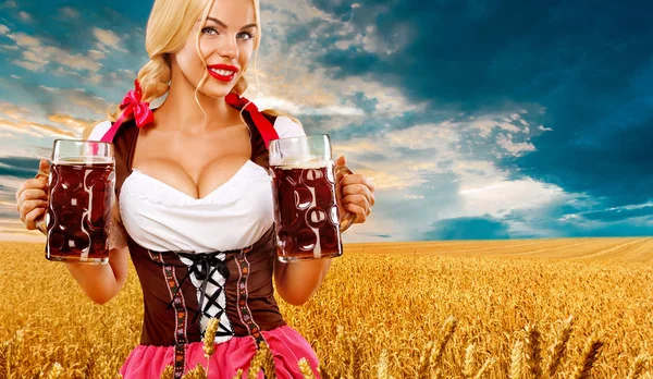 Partia piwa. Sexy kobieta Oktoberfest - kelnerka w sobie tradycyjny strój niemiecki Bawarii, Monachium serwujemy duże kufle na tle pola pszenicy złotej. — Zdjęcie stockowe