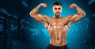 Spor salonunda ısınma fitness adam. Güçlü kas vücut geliştirmeci atlet. Vücut geliştirme ve spor kavram. Spor beslenme reklamlar için kopya alanı.