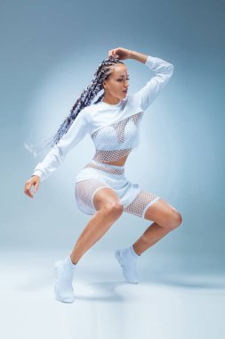 Çekici heyecanlı fitness kız mavi arka plan üzerinde izole eşofman dans dansçı. Moda ve livestyle kavramı.