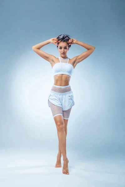 Attraente ballerina di fitness eccitata nella danza sportiva isolata su sfondo blu. Moda e livestyle concept . — Foto Stock