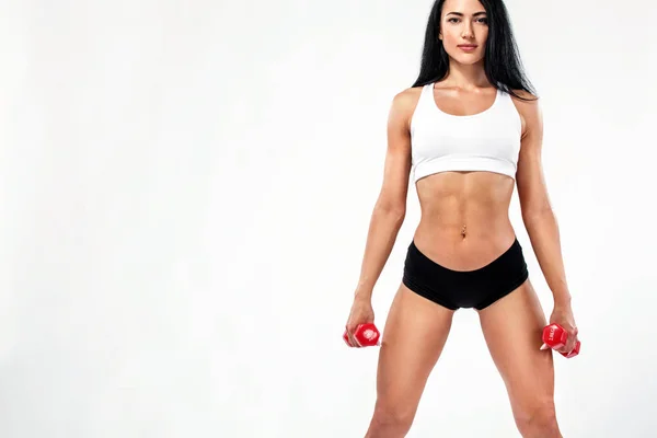 Fitness nő sportoló és testépítő gazdaság súlyzó. Elszigetelt fehér background. — Stock Fotó