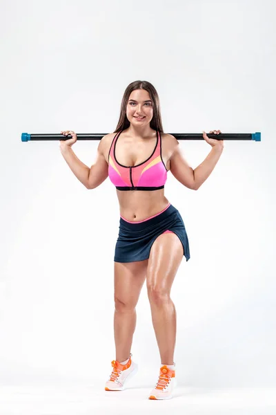 Gespierde fitness sport vrouw, atleet met sterke fit lichaam met lichaam bar op witte achtergrond. — Stockfoto