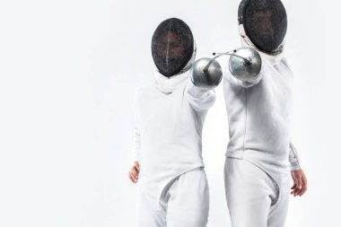 İki genç eskrimcilerin sporcular maskesi ve kostüm eskrim ve kılıç holding beyaz giyiyor. Beyaz arka plan üzerinde izole