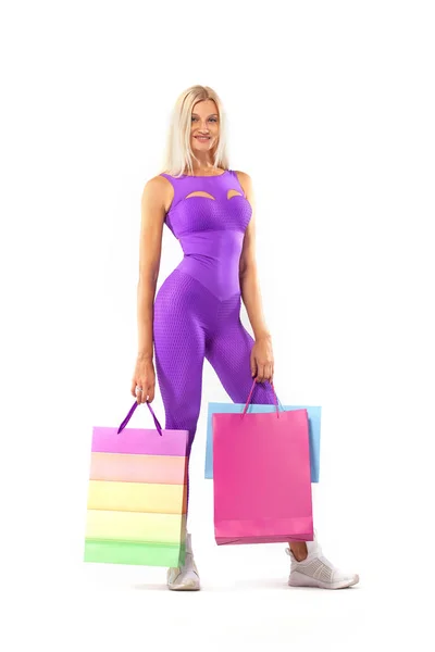 Black Friday concepto de venta para tiendas de fitness. Mujer de compras atleta sosteniendo bolsa de color aislado sobre fondo amarillo en vacaciones — Foto de Stock