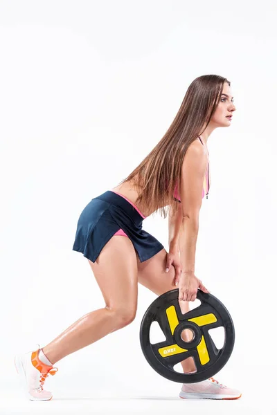 Mujer deportiva fitness muscular, atleta con cuerpo fuerte ajuste con barra sobre fondo claro . — Foto de Stock