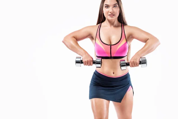 Attractive young fitness woman athlete and bodybuilder holding dumbbell on white background. — Stok fotoğraf