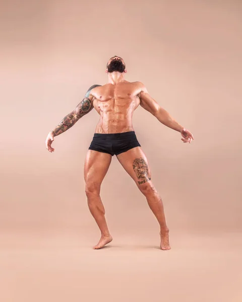 Muskulöser junger Fitnesssportler mit kräftigem Körper auf hellem Hintergrund. — Stockfoto
