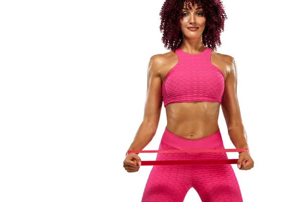 Mujer atleta deportiva musculosa joven en ropa deportiva rosa con bandas o expansor en el gimnasio. Espacio de copia para anuncios de nutrición fitness . — Foto de Stock