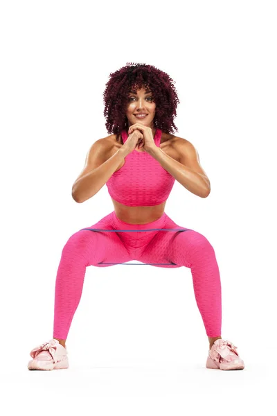 Mujer atleta deportiva musculosa joven en ropa deportiva rosa con bandas o expansor en el gimnasio. Espacio de copia para anuncios de nutrición fitness . — Foto de Stock