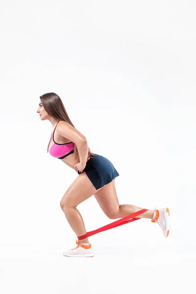 Mujer atleta fitness y culturista sosteniendo expansor o mini bandas. Concepto deportivo aislado sobre fondo blanco . — Foto de Stock