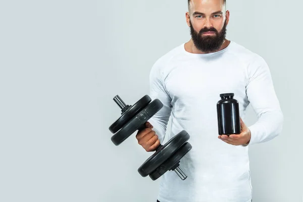 Muscular fitness sports man with a jar of sports nutrition - protein, gainer and casein