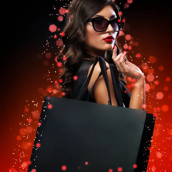 아름다운 여성이 금요일에 쇼핑을 합니다 가방을 어두운 배경에 — 스톡 사진