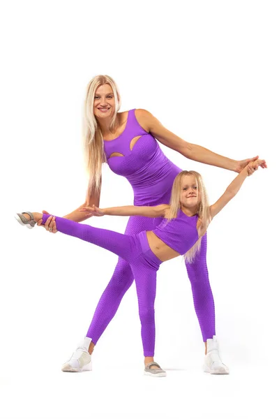 Concepto del día de las madres. Joven madre e hija hacen ejercicio juntos en el interior. Aspecto familiar . — Foto de Stock