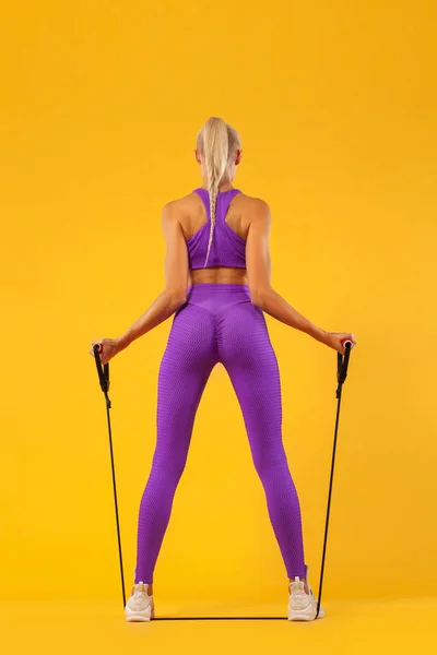 Fitness femme athlète et bodybuilder tenant extenseur. Isolé sur fond jaune . — Photo