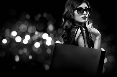 Noel veya Black friday Satılık kavramı. Kadın ihale bokeh ile koyu arka plan üzerinde tatil alışveriş. BW fotoğraf.