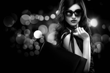 Noel veya Black friday Satılık kavramı. Kadın ihale bokeh ile koyu arka plan üzerinde tatil alışveriş. BW fotoğraf.