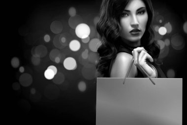 Noel veya Black friday Satılık kavramı. Kadın ihale bokeh ile koyu arka plan üzerinde tatil alışveriş. BW fotoğraf.