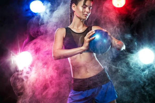 Bela fitness mulher atleta e fisiculturista com corpo perfeito fazendo trainging com medicina bola fundo . Fotos De Bancos De Imagens Sem Royalties