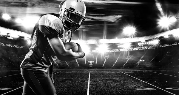 Jugador de fútbol americano, atleta en casco con pelota en el estadio. Foto en blanco y negro. Fondo de pantalla deportivo con copyspace . —  Fotos de Stock