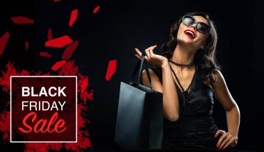 Kara Cuma indirim konsepti. Gri çantalı alışveriş yapan kadın tatilde karanlık arka planda izole edilmiş.