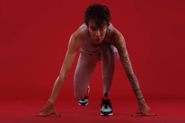 Bir güçlü atletik, kadın sprinter, spor, fitness ve spor motivasyon üzerinde kırmızı bir arka plan üzerinde çalışan için reay. Runner kavramı kopya alanı ile.