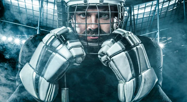 Ishockeyspelare i hjälm och handskar på stadion med pinne. — Stockfoto