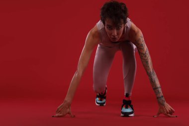Bir güçlü atletik, kadın sprinter, spor, fitness ve spor motivasyon üzerinde kırmızı bir arka plan üzerinde çalışan için reay. Runner kavramı kopya alanı ile.