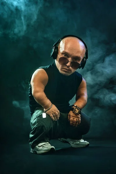 Портрет стильного посередника MC з навушниками та сонцезахисними окулярами, які позують з мікрофоном . — стокове фото