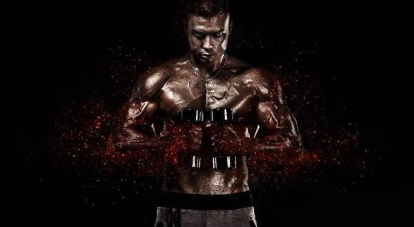 Мускулистый спортсмен, атлет с гантелями в тренажерном зале. Огонь и власть . — стоковое фото