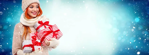 De vakantie van Kerstmis en Nieuwjaar. Gelukkig readhead vrouw met geschenken. Winkelen vrouw met geschenkdozen op de achtergrond van de winter met sneeuw. Verkoop poster met kopie ruimte. — Stockfoto