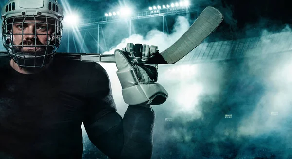 冰球运动员在头盔和手套在体育场与棍子. — 图库照片