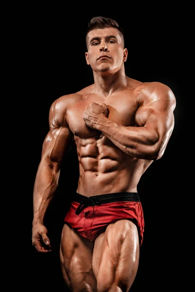 Brutale sterke gespierde bodybuilder atleet man oppompen van spieren op zwarte achtergrond. Training bodybuilding concept. Ruimte voor sport voeding advertenties kopiëren. — Stockfoto