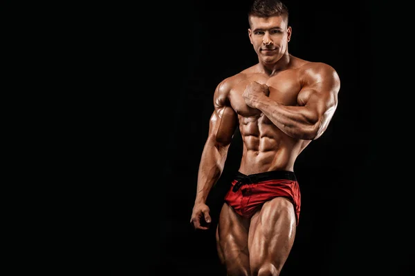 Brutale starke muskulöse Bodybuilder Athlet Mann, der Muskeln auf schwarzem Hintergrund aufpumpt. Workout Bodybuilding Konzept. Kopierraum für Sporternährungsanzeigen. — Stockfoto