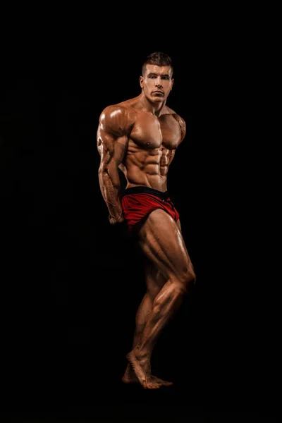 Brutale starke muskulöse Bodybuilder Athlet Mann, der Muskeln auf schwarzem Hintergrund aufpumpt. Workout Bodybuilding Konzept. Kopierraum für Sporternährungsanzeigen. — Stockfoto