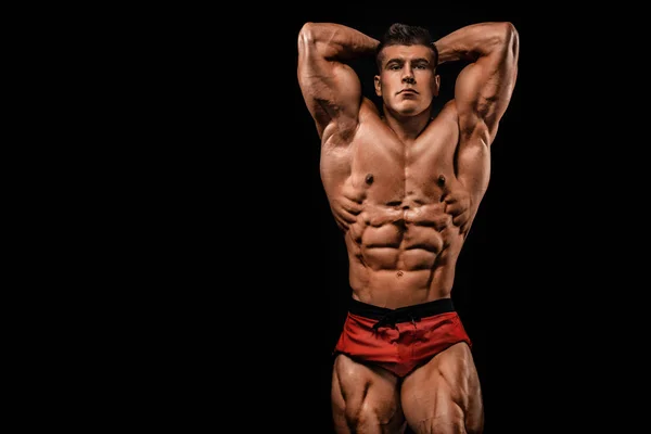 Brutalt starka muskulösa bodybuilder idrottsman man pumpa upp muskler på svart bakgrund. Träning bodybuilding koncept. Kopiera utrymme för sport nutrition annonser. — Stockfoto