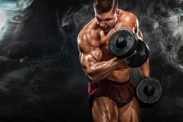 Brutal forte musculoso homem atlético fisiculturista bombeando os músculos com halteres no fundo preto. Conceito de musculação treino. Espaço de cópia para anúncios de nutrição esportiva . — Fotografia de Stock